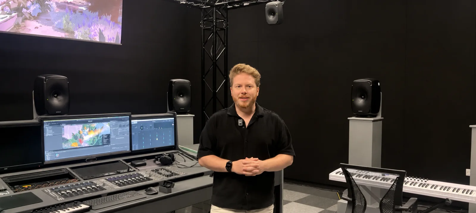 Ben Weatherill in an immersive audio studio, surrounded by Genelec monitors and a mixing console
